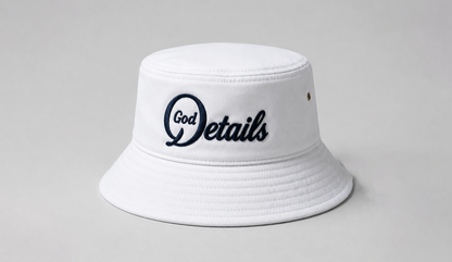 White bucket hat with 'God Details' logo on a gray background